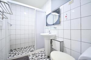 Baño blanco con aseo y lavamanos en Jamie home stay, en Taitung