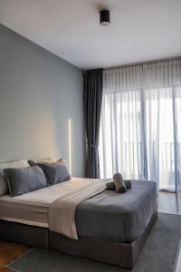 1 dormitorio con 1 cama grande y ventanas grandes en The Landmark Penang by Stay Premium, en Tanjong Tokong