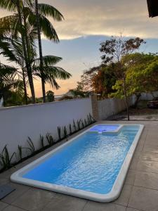 a swimming pool on a patio with a fence and trees at Chalé Rute Bilby Alter Do Chão in Santarém