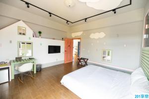 馬公市的住宿－撒野旅店，一间卧室配有一张床和一张书桌