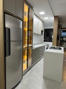 a kitchen with a stainless steel refrigerator and a stove at Apartamento 2 quartos home club na praia de palmas in Governador Celso Ramos