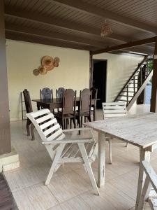 drewniany stół i krzesła na werandzie ze stołem i krzesłami w obiekcie Chalé Rute Bilby Alter Do Chão w mieście Santarém