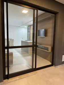 a room with a sliding glass door with a television at Apartamento 2 quartos home club na praia de palmas in Governador Celso Ramos