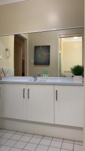 ein Badezimmer mit einem Waschbecken und einem großen Spiegel in der Unterkunft At holiday house in Woollamia