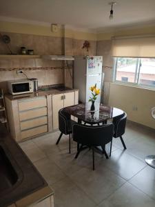 a kitchen with a table with a vase of flowers on it at Departamento Letty - con cochera in San Salvador de Jujuy