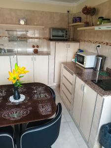 una pequeña cocina con mesa de madera y microondas en Departamento Letty - con cochera en San Salvador de Jujuy