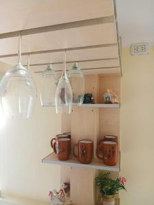 a kitchen shelf with three glass lights and mugs at Departamento Letty - con cochera in San Salvador de Jujuy