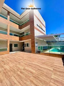 a large building with a swimming pool in front of it at Flat Gean Guilherme - Canasvieiras in Florianópolis