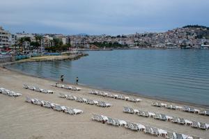 a beach with chairs and people on the water at KUŞADASI’NDA SAHİLE 200 METRE in Kusadası