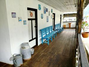 Une rangée de bancs bleus dans un couloir religieux dans l'établissement La Casona Pilaló, 