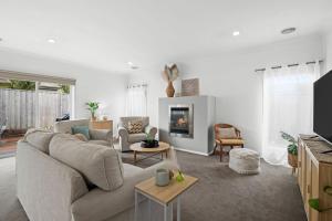 ein Wohnzimmer mit Sofa und Kamin in der Unterkunft Salty Sage Beach House in Torquay