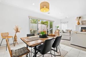 a living room with a wooden table and chairs at Salty Sage Beach House in Torquay