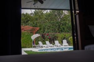 un grupo de sillas y una sombrilla junto a una piscina en Home La Fortuna, en Fortuna