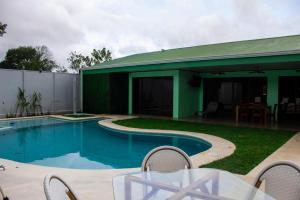 a swimming pool with a table and a house at Home La Fortuna in Fortuna