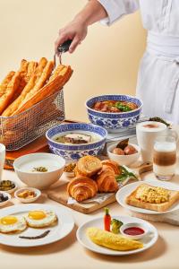 una mesa llena de comida con una persona que prepara comida en Hilton Suzhou en Suzhou