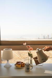 una mesa con una lámpara y un plato de comida y una ventana en The November Stay In landmark, en Incheon