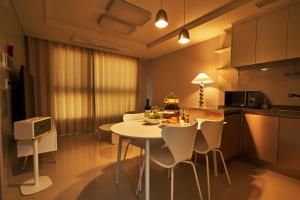 cocina y comedor con mesa blanca y sillas en The November Stay In landmark, en Incheon