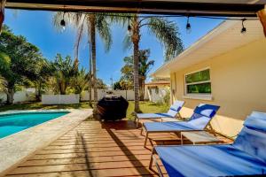 a patio with blue chairs and a swimming pool at Palm Lagoon Clearwater - 3 bedroom Resort House with heated pool & SPA in Clearwater