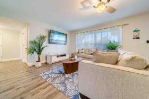a living room with a couch and a large window at Palm Lagoon Clearwater - 3 bedroom Resort House with heated pool & SPA in Clearwater
