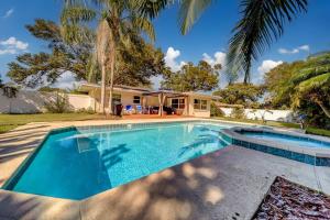 a swimming pool in front of a house at Palm Lagoon Clearwater - 3 bedroom Resort House with heated pool & SPA in Clearwater