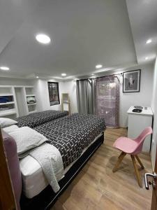 1 dormitorio con 1 cama y 1 silla rosa en Natural Home Campanario, en Santiago