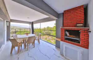 a dining room with a fireplace and a table and chairs at AGACH Apart 1 & 2 in Milas