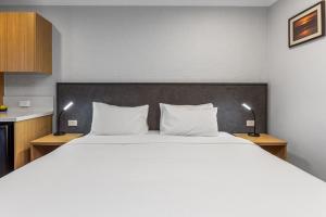 1 dormitorio con 1 cama blanca grande y 2 lámparas en Apollo Bay Motel & Apartments, BW Signature Collection, en Apollo Bay