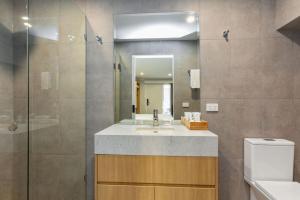 La salle de bains est pourvue d'un lavabo, d'un miroir et de toilettes. dans l'établissement Apollo Bay Motel & Apartments, BW Signature Collection, à Apollo Bay