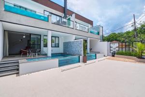 an exterior view of a house with a swimming pool at Villa da Serra 2 - Casa com piscinas privativas vidro in Paraty