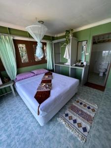 a bedroom with a large bed and a bathroom at Apsara & Dragon’s Supra Wellness Resort in Baan Tai