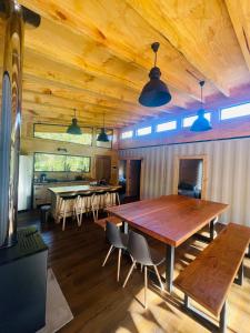 Pucura Eco Lodge في ليكانراي: غرفة طعام مع طاولة وكراسي خشبية