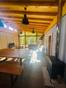 sala de estar con techo de madera y mesa en Pucura Eco Lodge, en Licán Ray