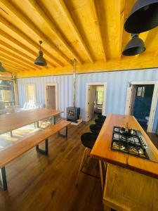 una gran sala de estar con techos de madera y mesas de madera. en Pucura Eco Lodge, en Licán Ray