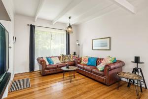 een woonkamer met 2 leren banken en een televisie bij George's at Rye in Rye