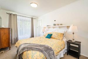 een slaapkamer met een bed, een lamp en een raam bij George's at Rye in Rye