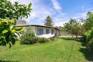 een klein wit huis in een grasveld bij George's at Rye in Rye