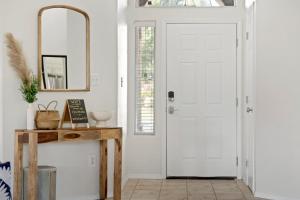 a hallway with a white door and a mirror at Revitalizing 3 Bedroom Home With Pool, Pet-Friendly, Wi-fi in Bakersfield