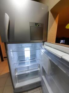 una nevera vacía con la puerta abierta en una cocina en Duplex tipo Casa Mendoza en Villa Hipódromo