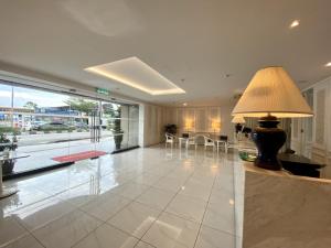 a large living room with a table and a lamp at Hotel 19, Penang in George Town