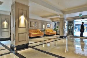 eine Lobby mit Sofas und Stühlen in einem Gebäude in der Unterkunft Chelsea Cloisters in London