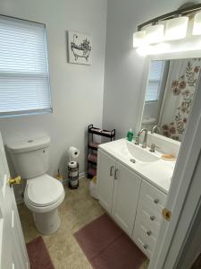 Baño blanco con aseo y lavamanos en The Chesapeake Gray en Norfolk