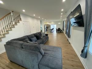 a living room with a large couch and a staircase at The Chesapeake Gray in Norfolk