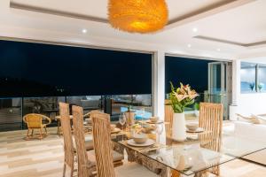 a dining room with a glass table and chairs at Luxury 5 bedroom oceanview villa in Bophut with Staff in Amphoe Koh Samui