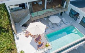 an overhead view of a pool with chairs and an umbrella at Luxury 5 bedroom oceanview villa in Bophut with Staff in Amphoe Koh Samui