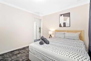 Un dormitorio blanco con una cama grande. en 8 Cute Cunningham Close To Subiaco - Sleeps 4, en Perth