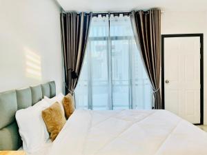 1 dormitorio con cama blanca y ventana en Sky View Home and Hostel Chiangmai, en Chiang Mai