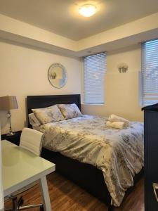 a bedroom with a bed and a desk and windows at Cozy Private Room, Walk to Wilson Station in Toronto