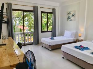 パングラオにあるラ シレニータのベッド2台とバルコニーが備わるホテルルームです。