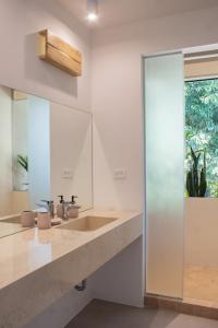 a bathroom with a sink and a mirror at D'Palm Villas in Puntarenas