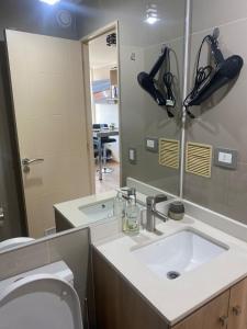 La salle de bains est pourvue d'un lavabo, de toilettes et d'un miroir. dans l'établissement DEPARTAMENTO ARAUCO CENTRO CHILLAN Con ESTACIONAMIENTO, à Chillán